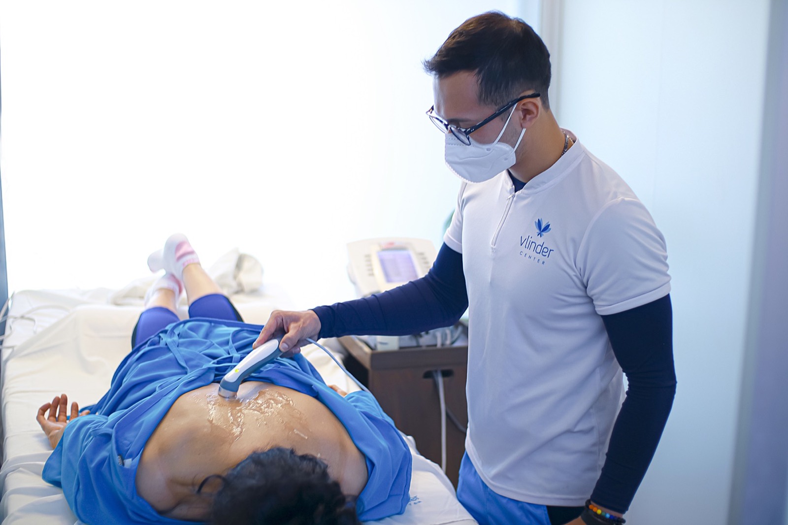 Terapeuta de Vlinder Center aplicando tratamiento con equipo sobre la espalda de una invitada